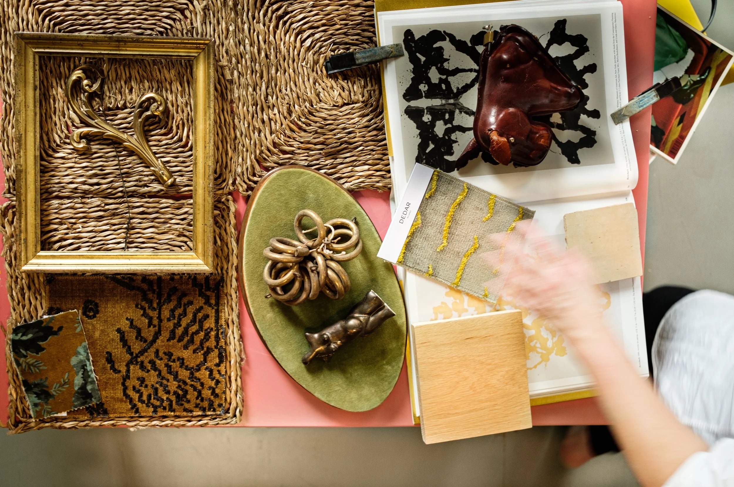 An overhead view of Hallie Goodman's material moodboard with gilt frames, textiles and vintage objects